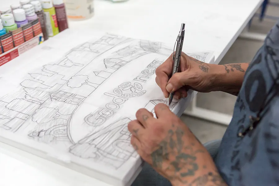 artist drawing artwork in pencil at art house in Community First! Village 